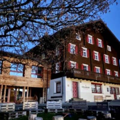 Alpenhaus bei Dämmerung mit rotem Fensterladen.
